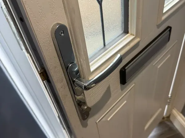 Chrome lever handle on a cream composite front door