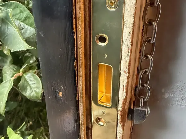New mortice keep fitted to a repaired timber door frame with door chain