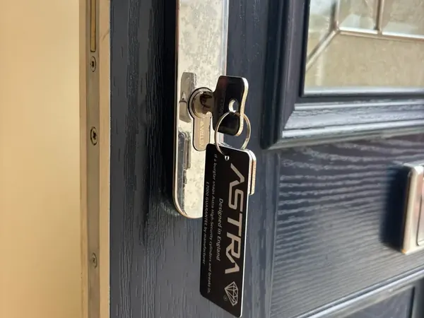 Euro cylinder with key tag on a dark composite door