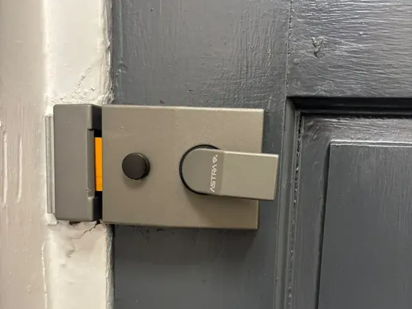 Grey nightlatch with deadlocking button on a grey painted door
