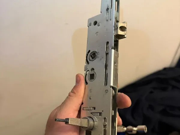 Locksmith holding a multipoint lock gearbox with spindle fitted