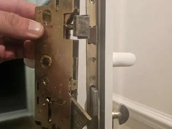 Worn multipoint lock mechanism held against the edge of a uPVC door