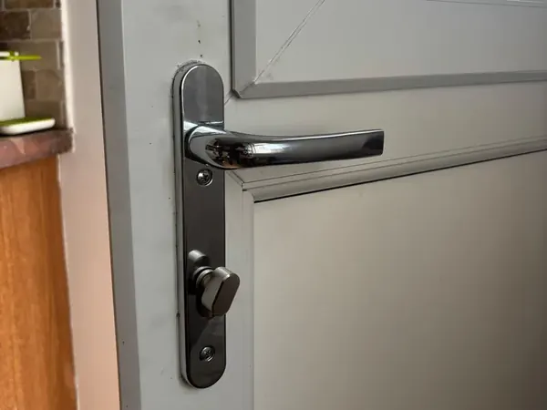 Chrome lever handle and thumbturn on a white uPVC door