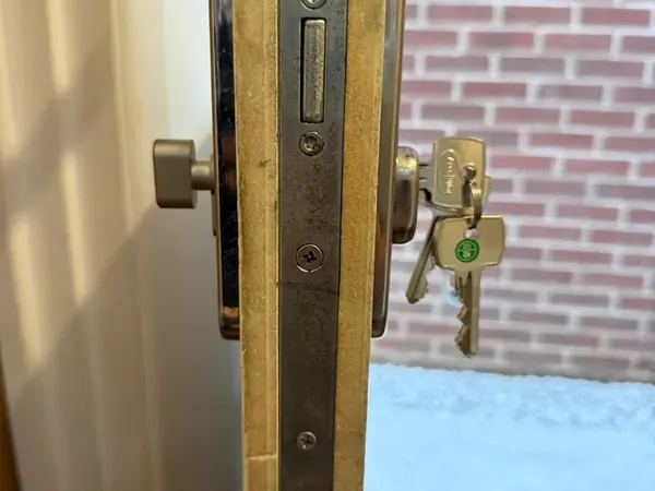 Edge of a uPVC door showing multipoint lock keeps and thumbturn with new keys